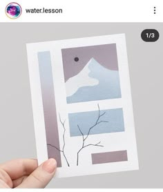 a hand holding up a card with an image of a tree and mountains in the background