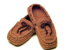 two brown crocheted slippers with bows on the top and bottom, sitting next to each other