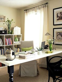 a home office with bookshelves and pictures on the wall