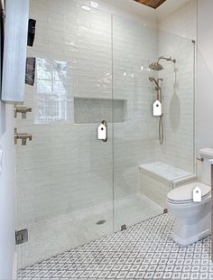 a bathroom with a walk in shower next to a white toilet and sink under a wooden ceiling