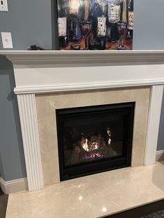 a fire place with a painting on the wall