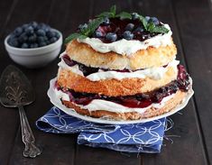 a layered cake with blueberries and whipped cream