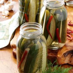 pickled cucumbers in jars on a cutting board