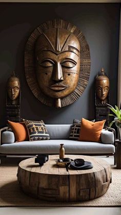 a living room with a couch, coffee table and african masks on the wall behind it