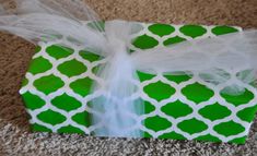 a green and white gift box on the floor