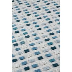 a blue and white rug with small squares on the top, in different sizes and colors