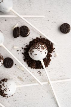 chocolate cake pops with oreo cookies on top and white sticks sticking out of them