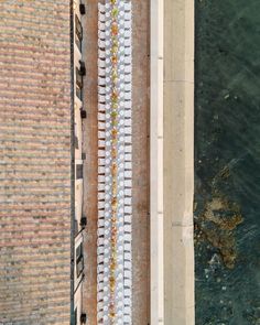 an aerial view of a long table set up on the side of a building by the water