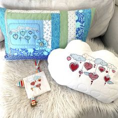 two pillows and a pillow on a white furnishing with hearts in the background