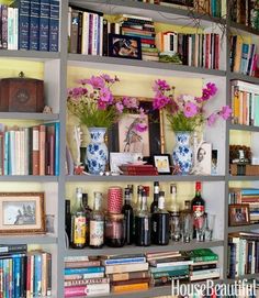 a book shelf filled with lots of books and vases on top of it's shelves