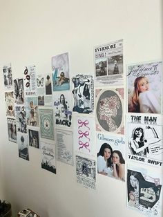 a white wall covered in posters and pictures