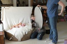 a woman is holding a baby in a hammock while another woman looks on