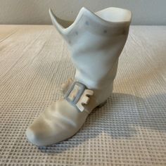 This Lladró Nao figurine is a stunning piece that will add a touch of elegance to any collection. The Warrior Musketeer Buckle Boot is crafted from high-quality porcelain and has a matte finish that complements any decor. Measuring at 4 inches in length, this figurine is the perfect size for display on a shelf or table.  The intricate details of the warriors armor and boots are impressive, and the fact that this piece is an original from Spain makes it a unique addition to any collection. This L Buckle Boots, High Quality, Spain, Converse, Buckle, Porcelain, Figurines, Statue, Boots