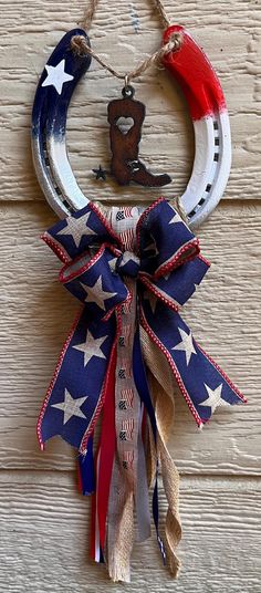 an american flag wreath hanging on the side of a wooden door with a horseshoe and star decoration