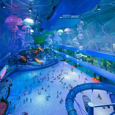 an indoor water park with people playing and swimming