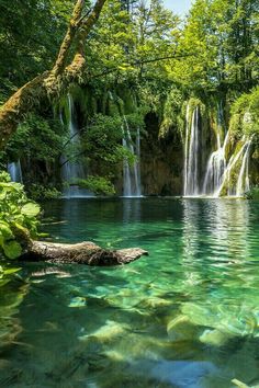 the water is crystal green and there are many small waterfalls in the backround