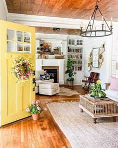 a living room filled with furniture and a fire place next to a doorway that leads into a kitchen