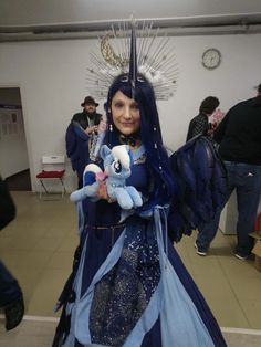 a woman dressed in blue holding a stuffed animal