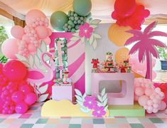 a party with balloons, palm trees and flamingos