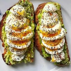 two pieces of bread with eggs and other toppings on it sitting on a plate