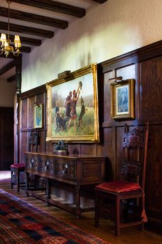 an ornate room with paintings on the wall and wooden paneling, along with a bench