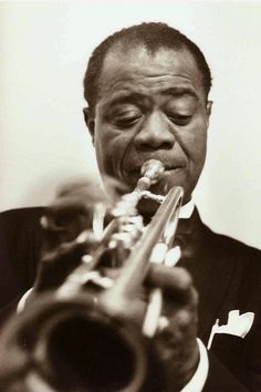 a black and white photo of a man playing a trumpet