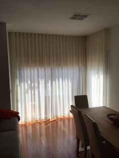 an empty living room with wooden floors and curtains