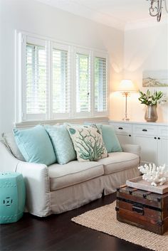 a living room filled with furniture and pillows on top of a hard wood floored floor