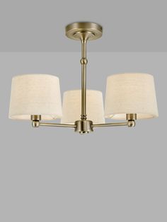 a chandelier with three lamps hanging from it's sides and two shades on the