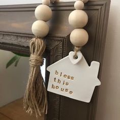 a white sign hanging from the side of a wooden door with a string attached to it