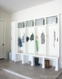 an entryway with several coats and boots hanging on the wall