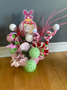 a vase filled with candy and candies on top of a hard wood floor next to a wall