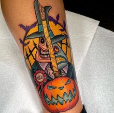 a person with a tattoo on their arm holding a knife and jack - o'- lantern