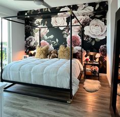 a bedroom with a floral wallpaper and four poster bed in the middle of it