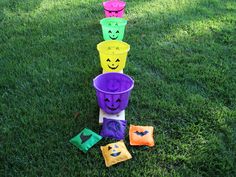 plastic cups with faces painted on them sitting in the grass