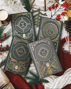 three tarot cards sitting on top of a table next to candles and christmas decorations