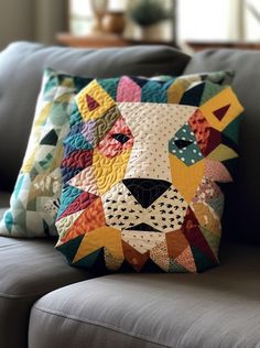 a pillow that has a patchwork lion on the front and side of it, sitting on a couch