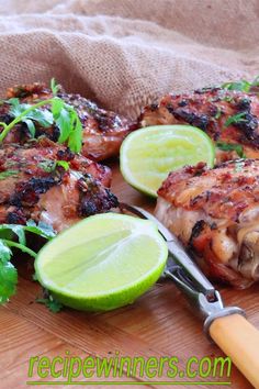 grilled chicken with garnishes and limes on a cutting board