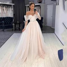 a woman is taking a selfie in her wedding dress while looking at her phone