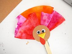 a paper plate with a turkey on it and a pair of scissors next to it