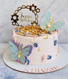 a birthday cake decorated with butterflies and gold