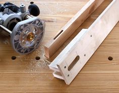 a machine that is sitting on top of a wooden table next to a piece of wood