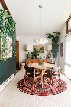 the dining room table is surrounded by two chairs and a rug with plants on it