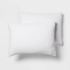 two white pillows sitting next to each other