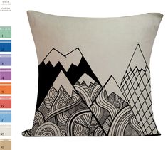 a black and white pillow with mountains in the background on an off - white background