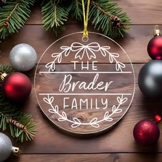 a glass ornament with the words, the bradley family on it surrounded by christmas ornaments