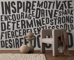 a chair sitting in front of a wall with black and white words written on it