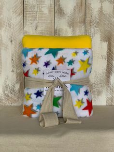 two baby swaddles with stars on them, one yellow and the other blue