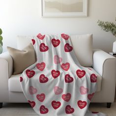 a white couch with a red heart blanket on it