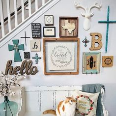 a cat sitting on top of a bench next to a wall with pictures and letters